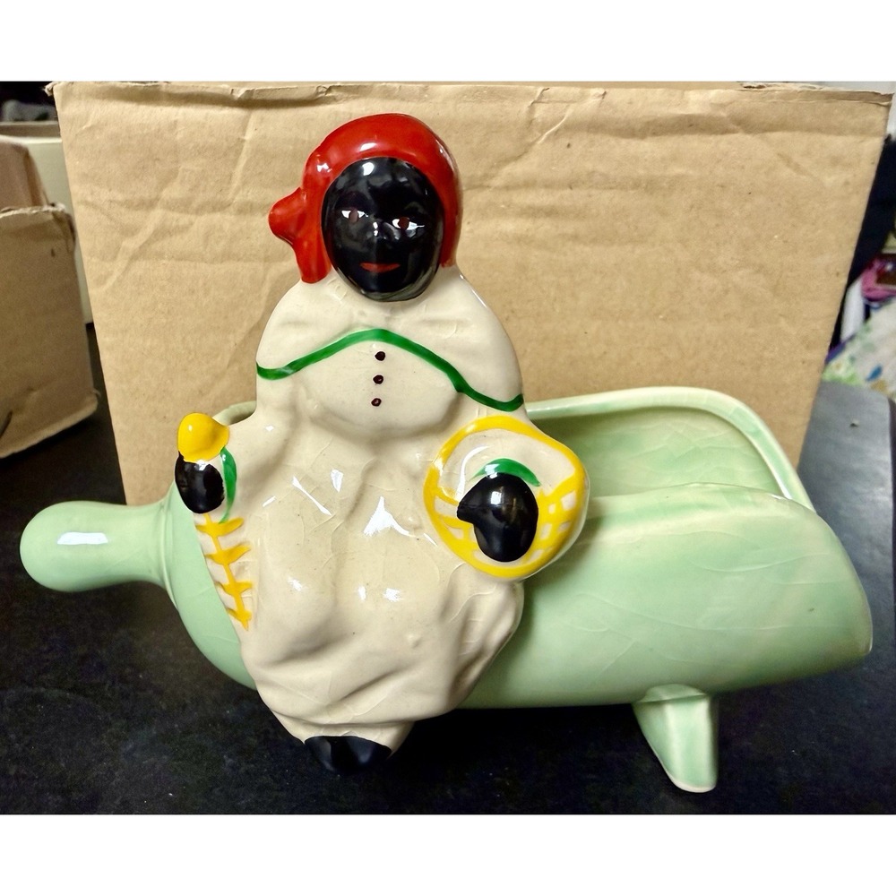 A McCoy Pottery Black Americana figure in a green scoop planter.